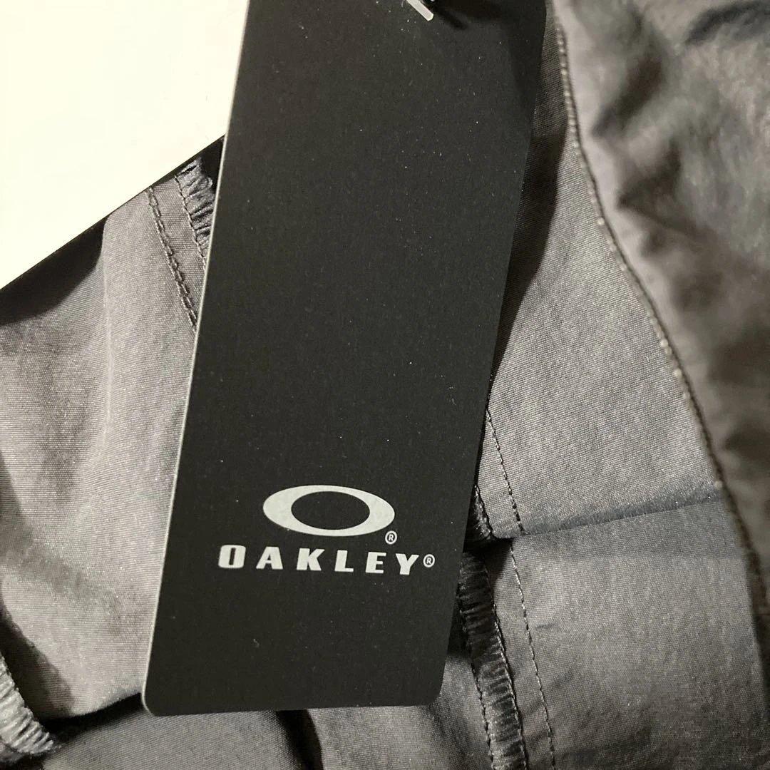 新品未使用タグ付きOAKLEYマットチャコールグレーピステウィンドブレーカーXL